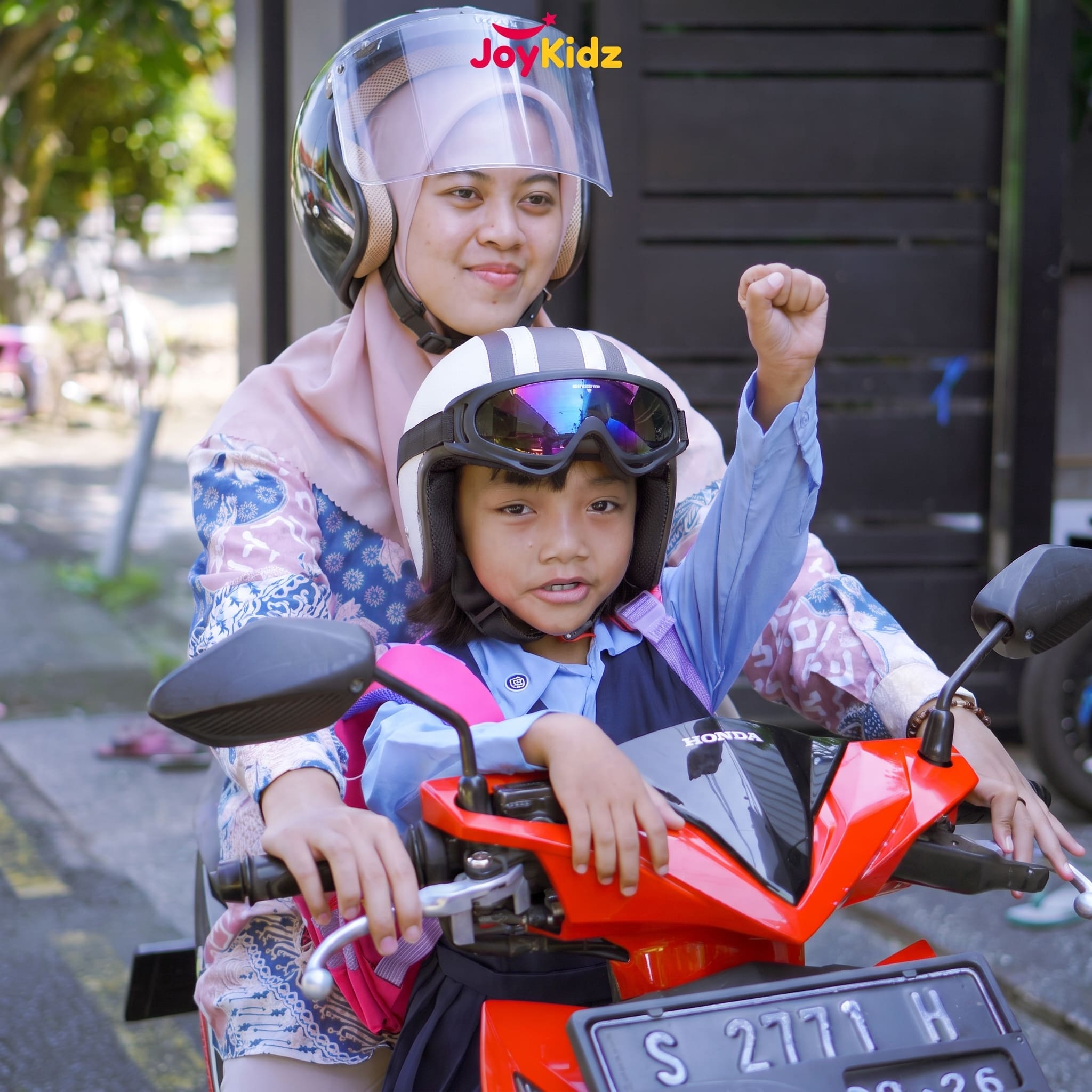 Ibu dan anak berboncengan motor, keduanya memakai helm JoyKidz